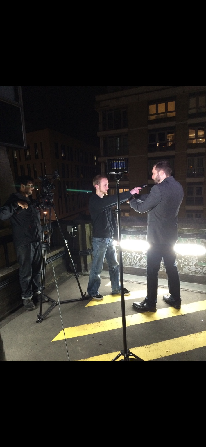 Actor and camera crew filming a scene on a night shoot