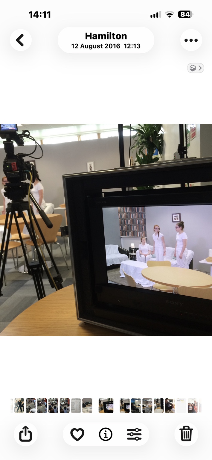 Camera and production monitor showing actors performing a scene